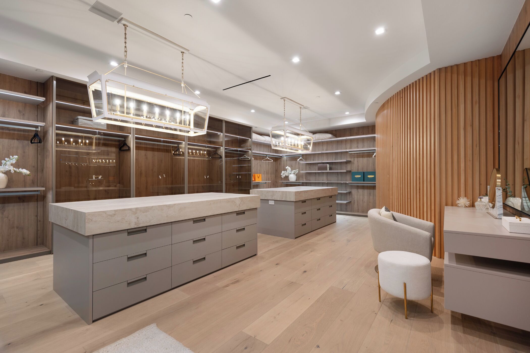 A modern bathroom with a large vanity, built-in shelves, and a wooden accent wall.