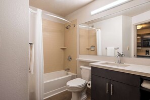 A modern bathroom with a bathtub, toilet, and vanity. - Modern Urban Retreat | Free Parking | Near Buffalo Ridge Park - 1.6 miles (Fort Worth)