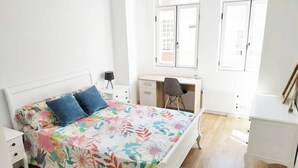 Quarto com uma cama, uma escrivaninha e uma cadeira.