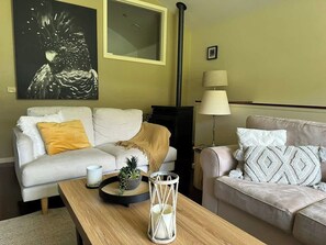 Ein Wohnzimmer mit zwei Sofas, einem Couchtisch, einer Lampe und einem Bild an der Wand.