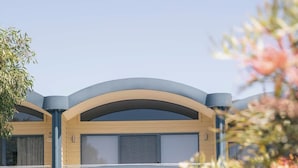 A modern two-story building with a covered entrance, large windows, and a visible number '6' on the facade. - Halls Gap Escape Townhouse 6 (Halls Gap)