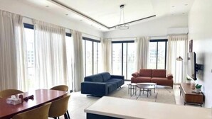 A modern living room with a dining area, sofas, and a coffee table. - Bright two-bedroom apartment with a balcony (Dakar)