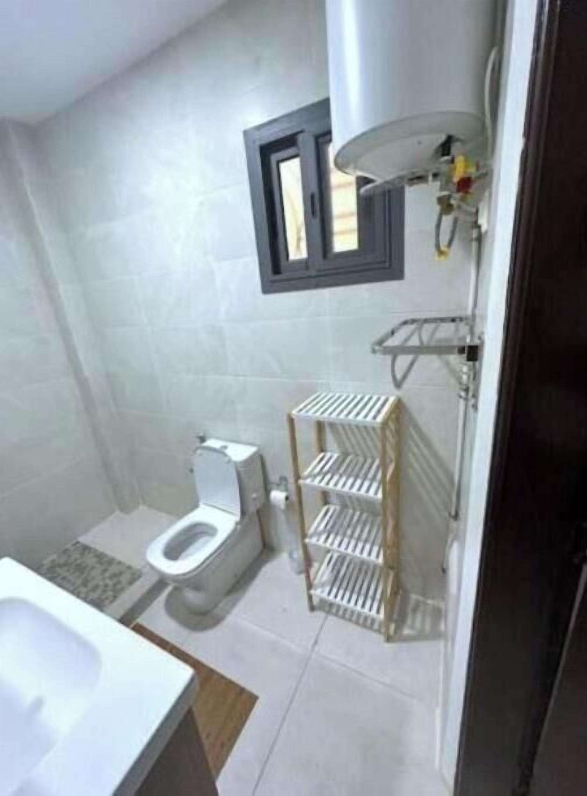 A bathroom with a toilet, a sink, and a shower area.
