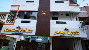 Un edificio de dos pisos con señalización que indica 'Ramana Palace' y 'Templo de Guruvayoor'.