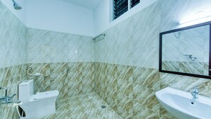 A bathroom with a toilet, sink, and shower.