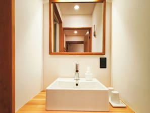 A bathroom with a rectangular sink, a mirror, and a wooden countertop. - Hygge Haus Kusatsu (Kusatsu)