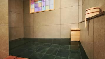 A small, tiled bathroom with a wooden bench, a wooden cabinet, and a stained glass window.