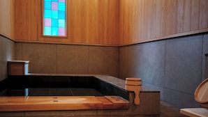 Ein Holzkamin mit Steinplattenboden, einer Holzbank und einem kleinen Hocker.
