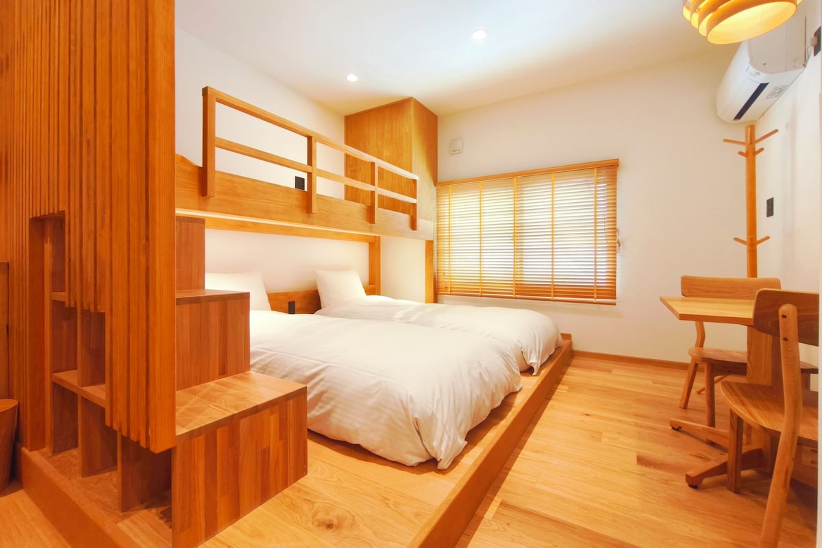 Une chambre moderne avec un lit superposé, des meubles en bois et un bureau.