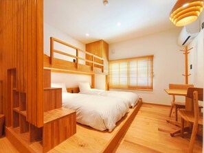 Un dormitorio moderno con una cama litera, muebles de madera y un escritorio.