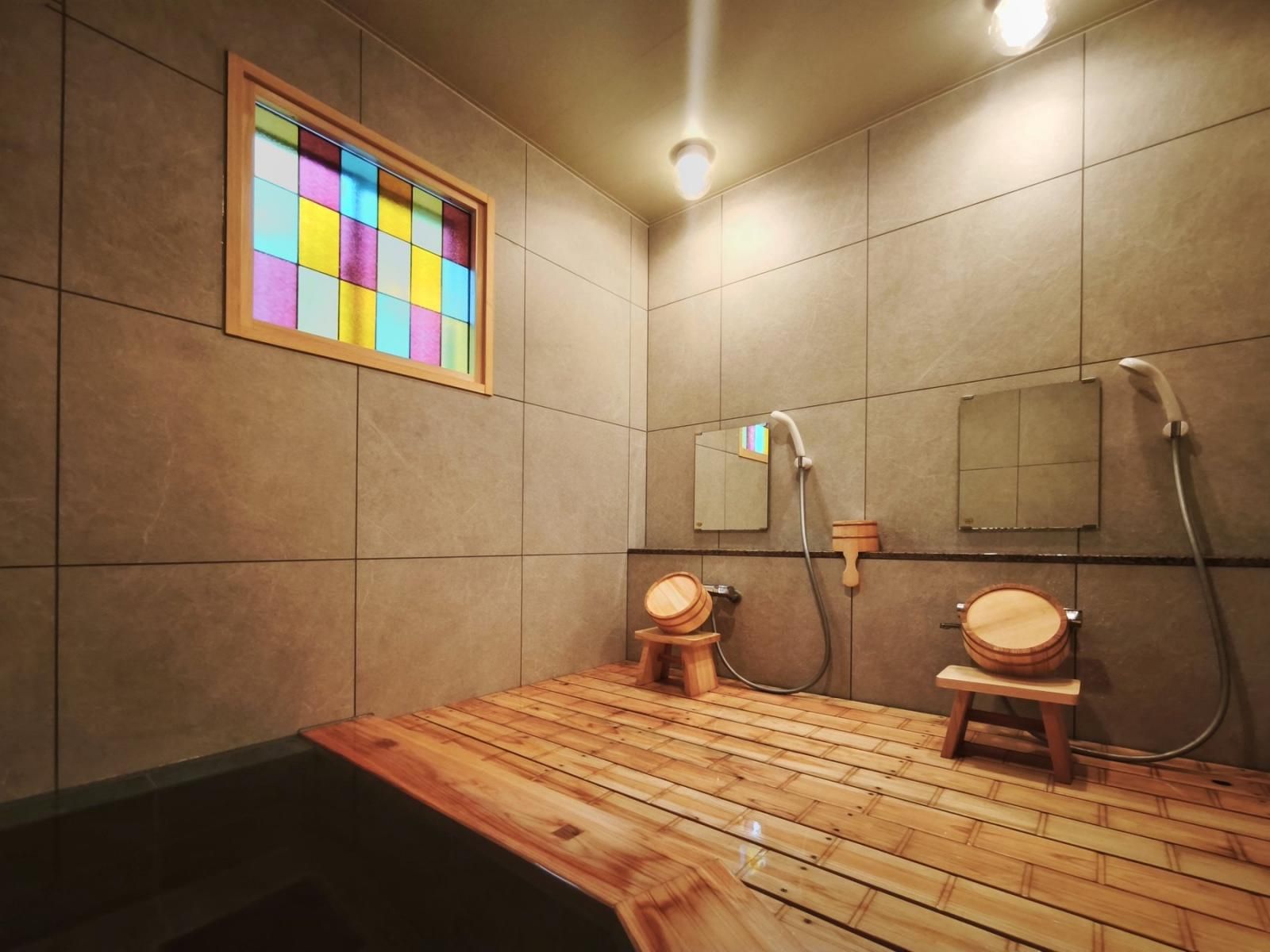 A bathroom with a wooden floor, a mirror, and a shower area.