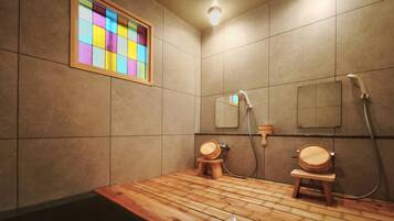 A bathroom with a wooden floor, a mirror, and a shower area.