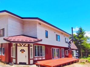 A two-story building with a red deck and a chimney.