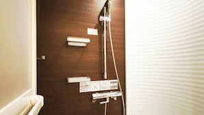 Ein Badezimmer mit Holztür, Duschkabine und Toilette.