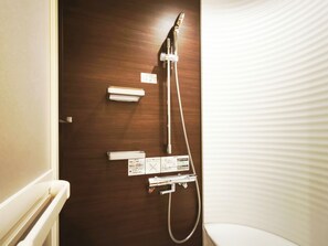 Une salle de bain avec une porte en bois, une douche et des toilettes.