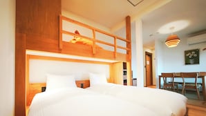 Ein Schlafzimmer mit zwei Betten, einem Schlafsofa und einem Schreibtisch mit Stuhl.