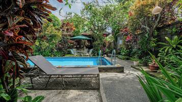 Piscina a l'aire lliure, para-sols i gandules
