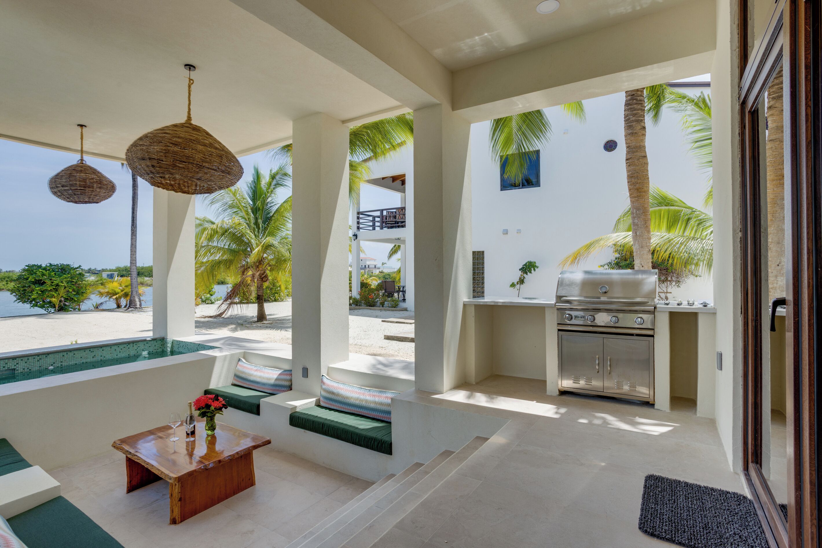 Un espace de vie extérieur moderne comprenant une piscine, des sièges et un barbecue.