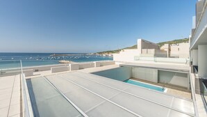 Une piscine sur le toit offrant une vue dégagée sur la mer et les bateaux.
