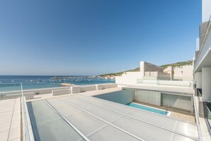 Ein Pool auf dem Dach mit freiem Blick auf das Meer und Boote.