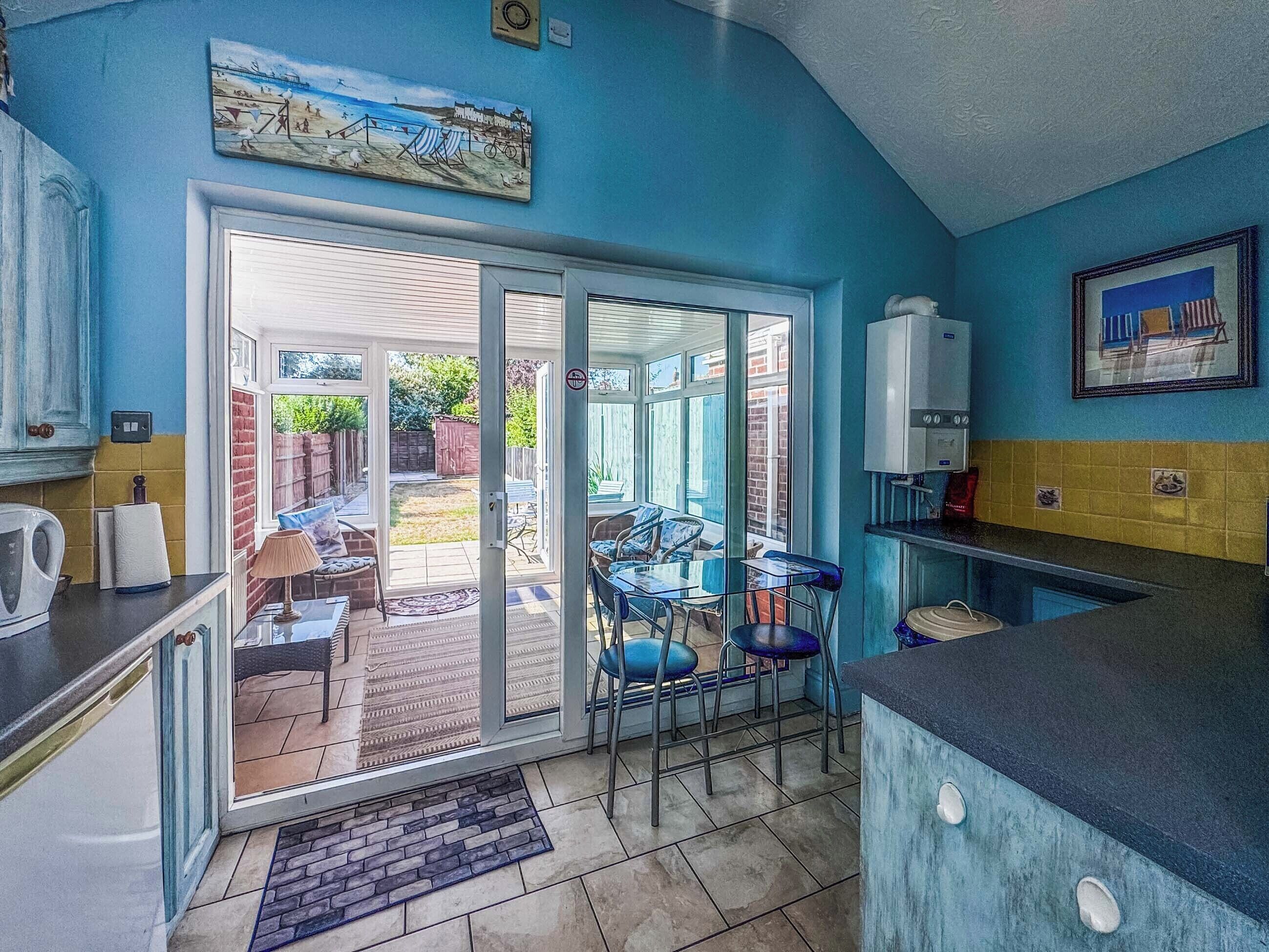 A kitchen with a sliding glass door leading to an outdoor seating area.