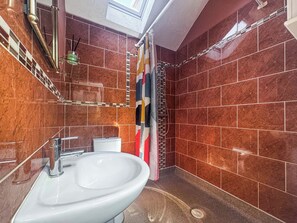 Ein Badezimmer mit Waschbecken, Toilette und Duschbereich.
