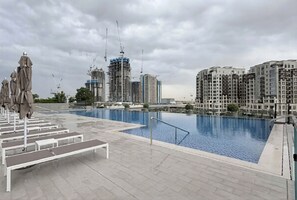 Ein Dachpool mit Blick auf hohe Gebäude, darunter eine Baustelle.