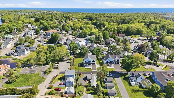 A residential area with houses, roads, and a body of water in the background. - Luxurious NEW Home|Walk To Town & BEACH|Pool Table|Fire Pit|Bikes (Kennebunk)