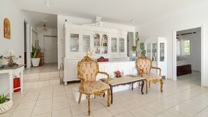 A spacious room with a white cabinet, two ornate chairs, and a tiled floor. - Room '1st Floor' with Sea View, Shared Pool and Wi-Fi (Nikiana)