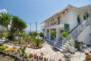 Ein weißes Gebäude mit Balkon und einer Treppe zum Eingang.