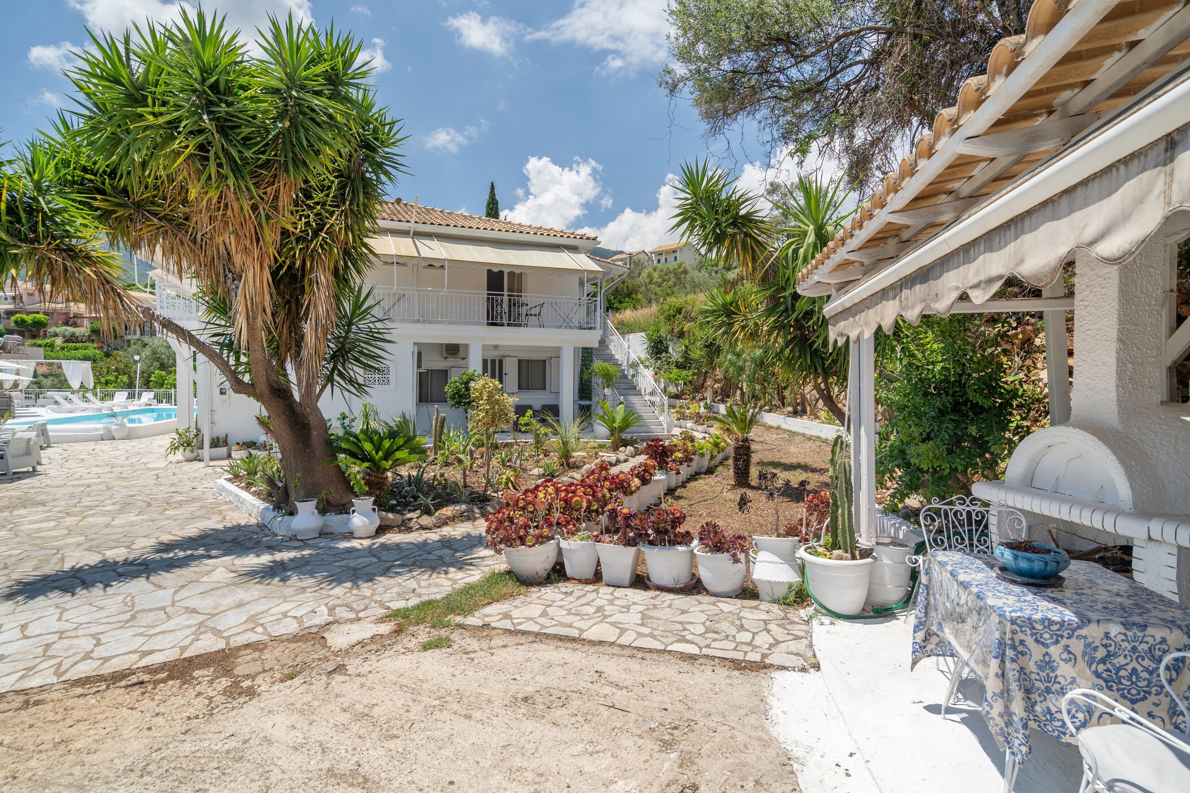 Une villa avec piscine, un espace salon extérieur et une terrasse couverte.