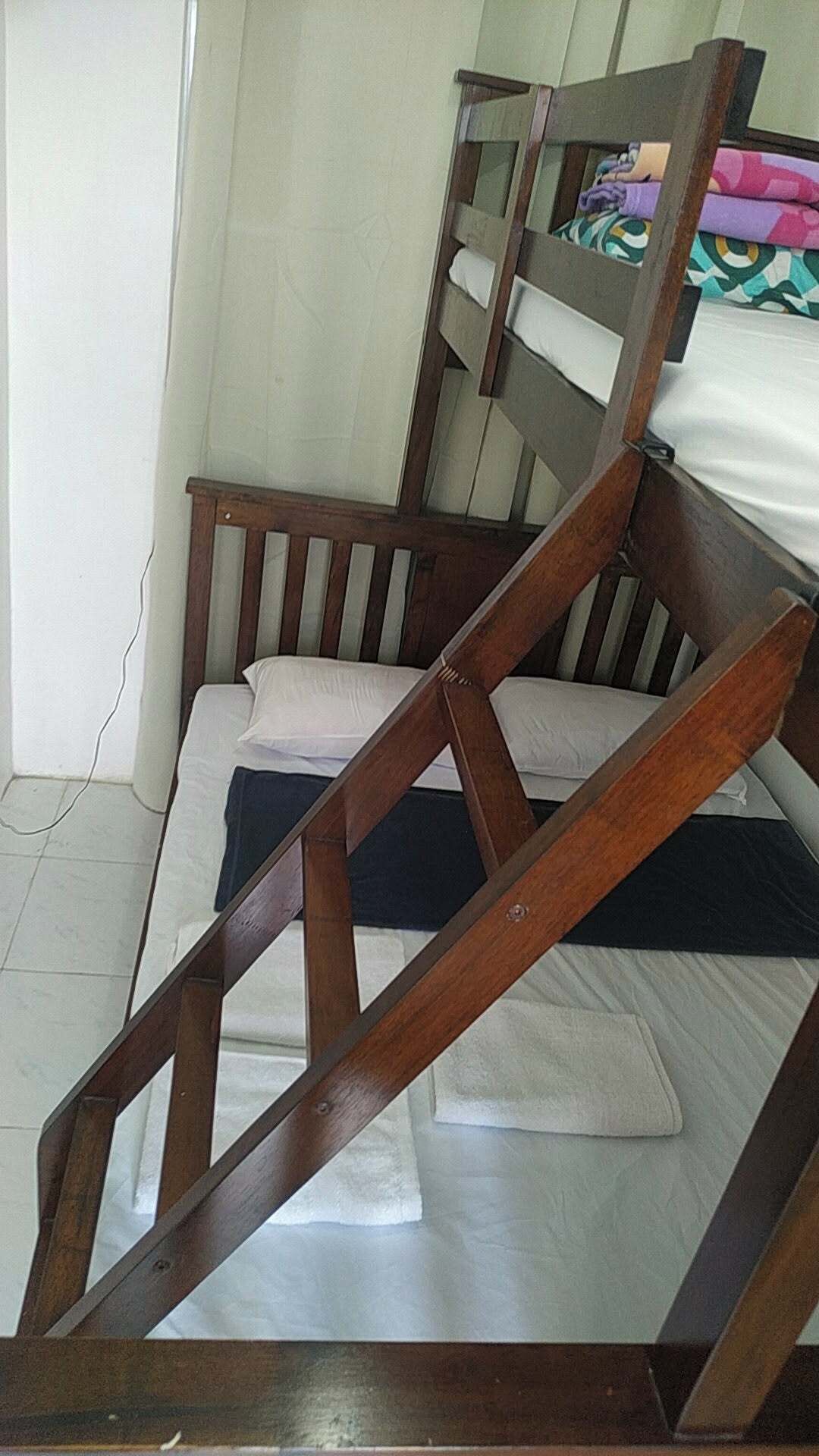 Un lit superposé avec une structure en bois et un matelas.