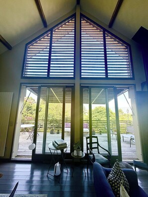 A spacious room with a high ceiling, large windows, and a view of the outdoors. - Villa Mont Baret (Menthon-Saint-Bernard)
