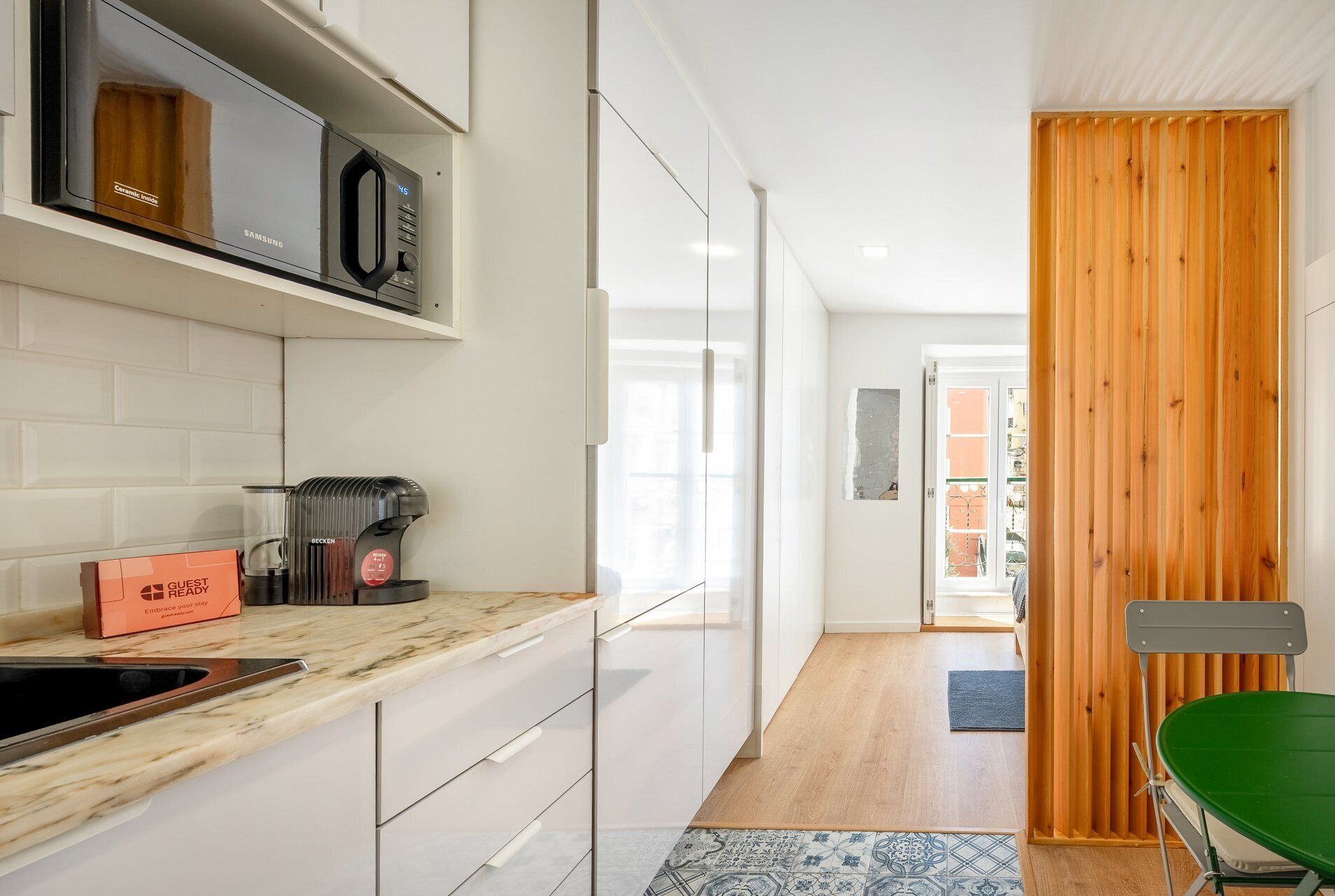 A modern kitchen with a microwave, coffee maker, and a 'Guest Ready' box.