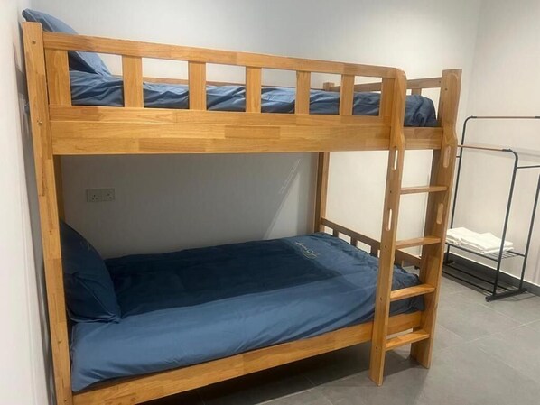 A bunk bed with a ladder, a metal rack, and a white towel rack.