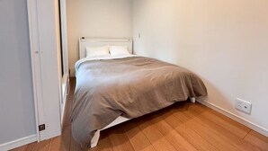 A bedroom with a bed, a door, and a light switch on the wall. - 10 minutes from Okayama Station | Exclusive use for one group | Groups welcome | Up to 6 guests | 1 parking space | Loft | 1 restroom | Long-term stays welcome (岡山市)