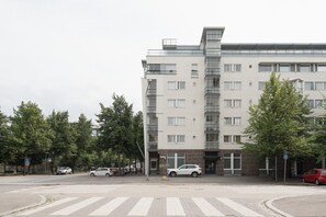 Een meerlaags gebouw met een modern architectonisch ontwerp, met een opvallende glazen gevel en meerdere balkons.