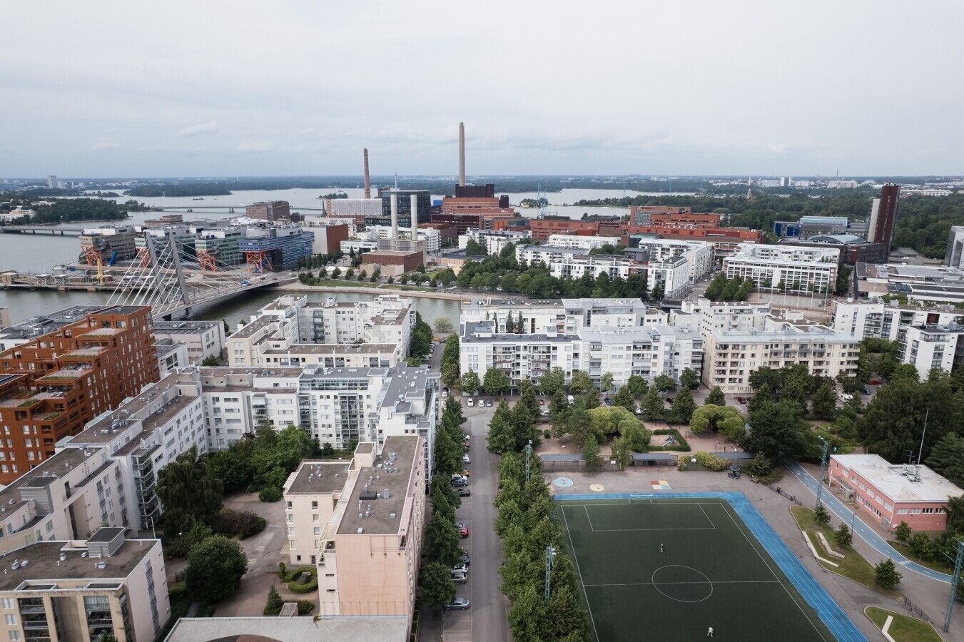 An urban landscape with residential buildings, a bridge, and a river.