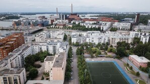 Kaupunkimaisema, jossa on asuinrakennuksia, silta ja joki.