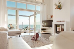 Ein modernes Wohnzimmer mit großem Fenster, Flachbildfernseher und Kamin.
