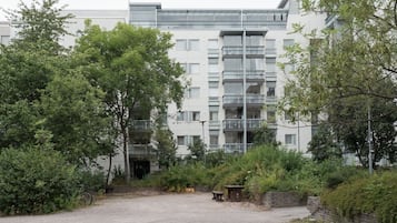 Un edificio moderno de varios pisos, rodeado de vegetación y un camino de grava.