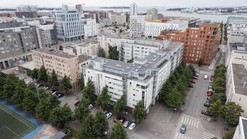 A multi-story building with a parking lot and trees in front.