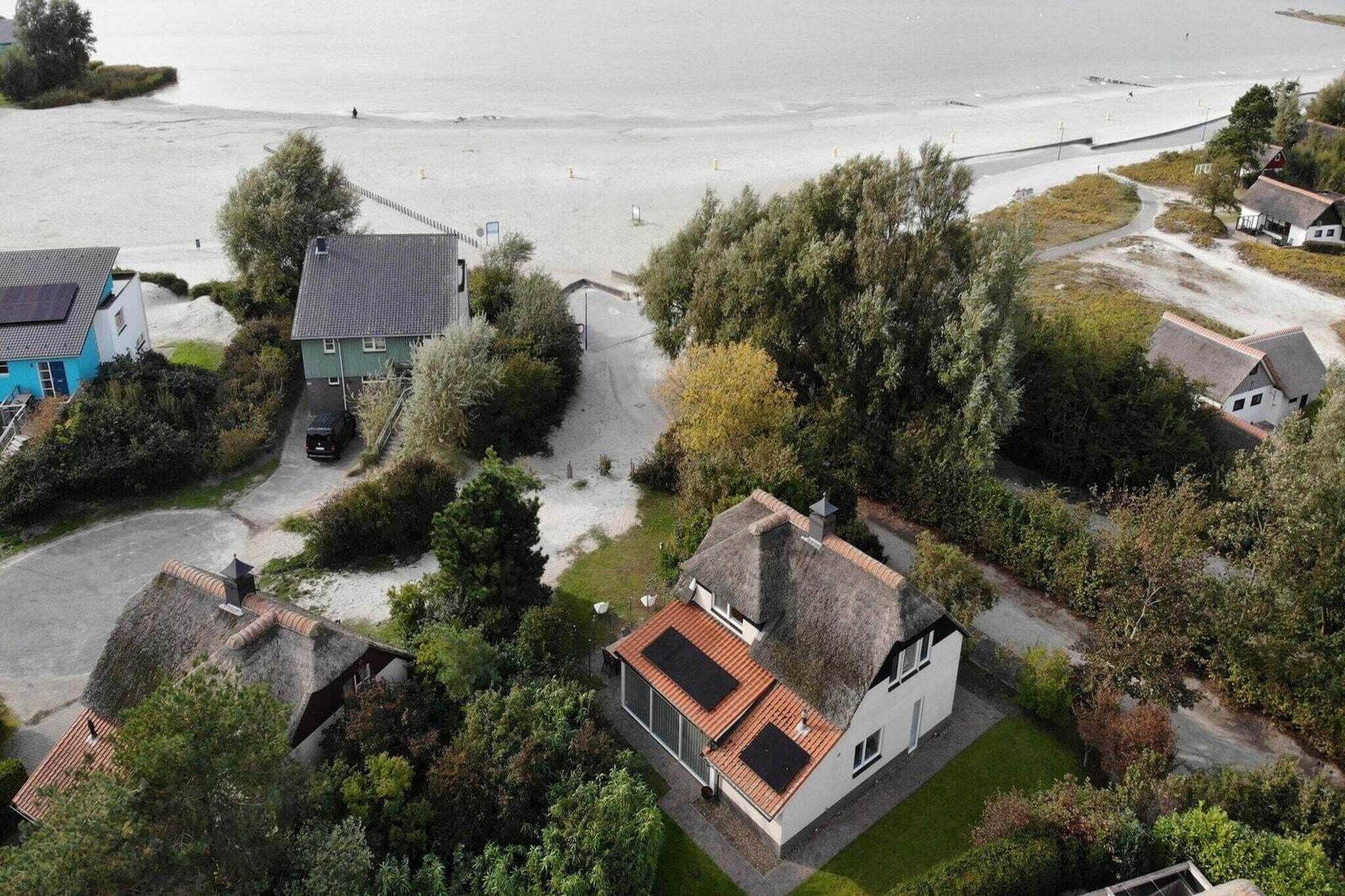 Een kustgebied met huizen, een strand en een weg die naar de zee leidt.
