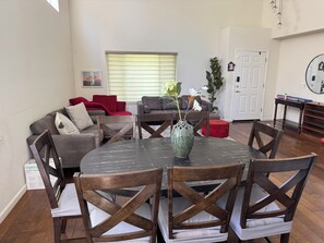 A dining area with a round table, wooden chairs, and a vase with flowers. - Gorgeous 4-bed, 3 bath house with AC in lovely San Jose (San Jose)