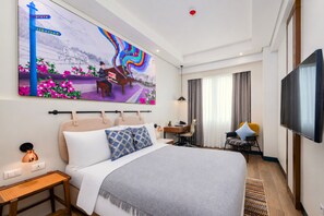 A hotel room with a large bed, a desk, a chair, a TV, and a painting on the wall.