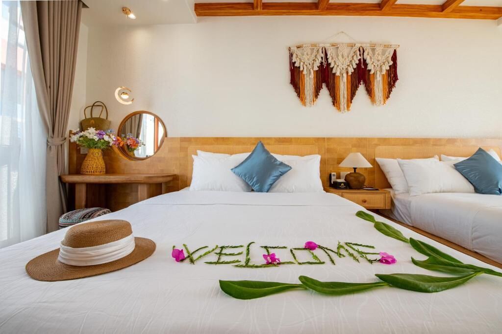 A hotel room with a bed, two bedside tables, a nightstand, a mirror, and a wall hanging.