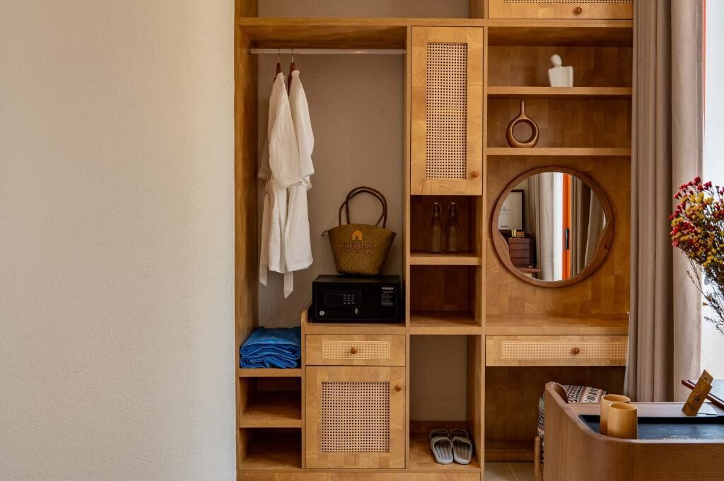 A wooden wardrobe with shelves, a hanging rack, and a mirror.