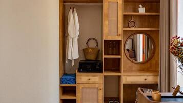 A wooden wardrobe with shelves, a hanging rack, and a mirror.