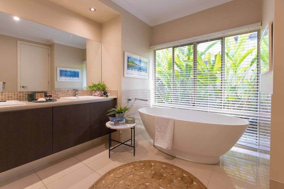 Un bagno moderno con una vasca freestanding, un mobile lavabo con specchio e una finestra con persiane.