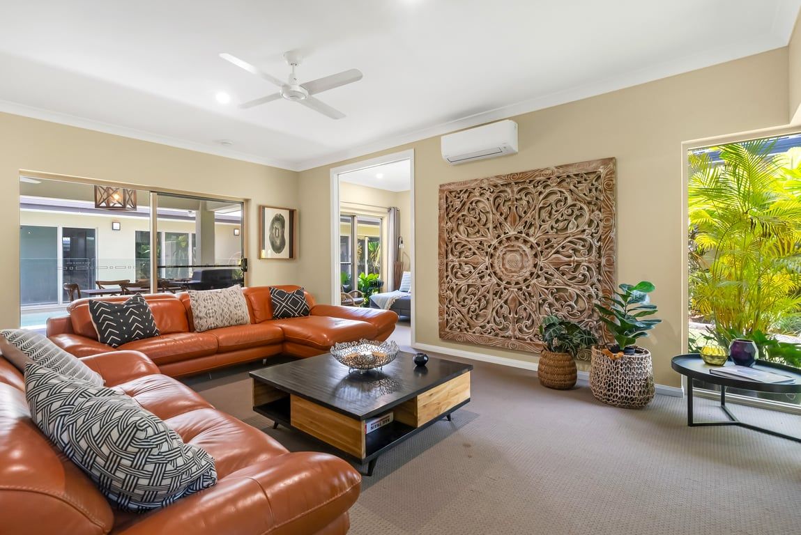 A modern living room with a leather sofa, a coffee table, and decorative wall panels.